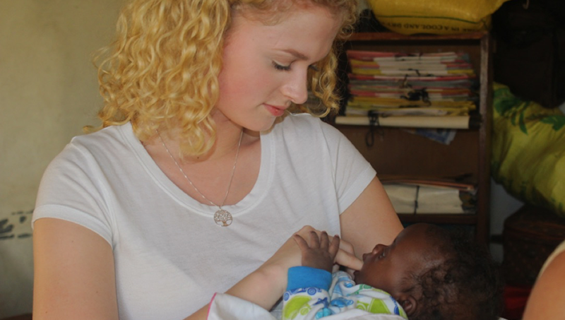 兰妮菲利普斯的形象在乌干达照顾一个婴儿。